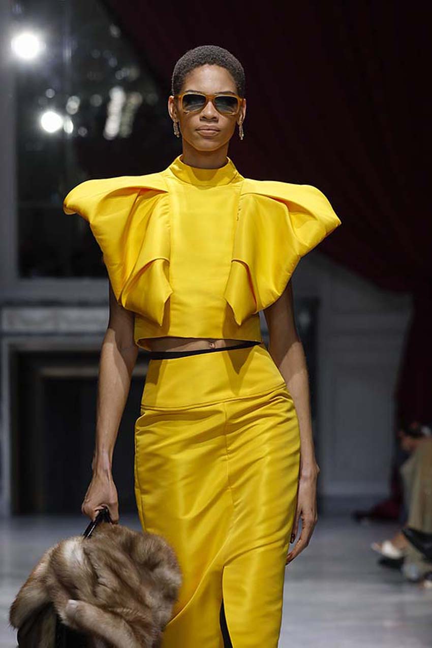Model wearing a bright yellow outfit on a runway