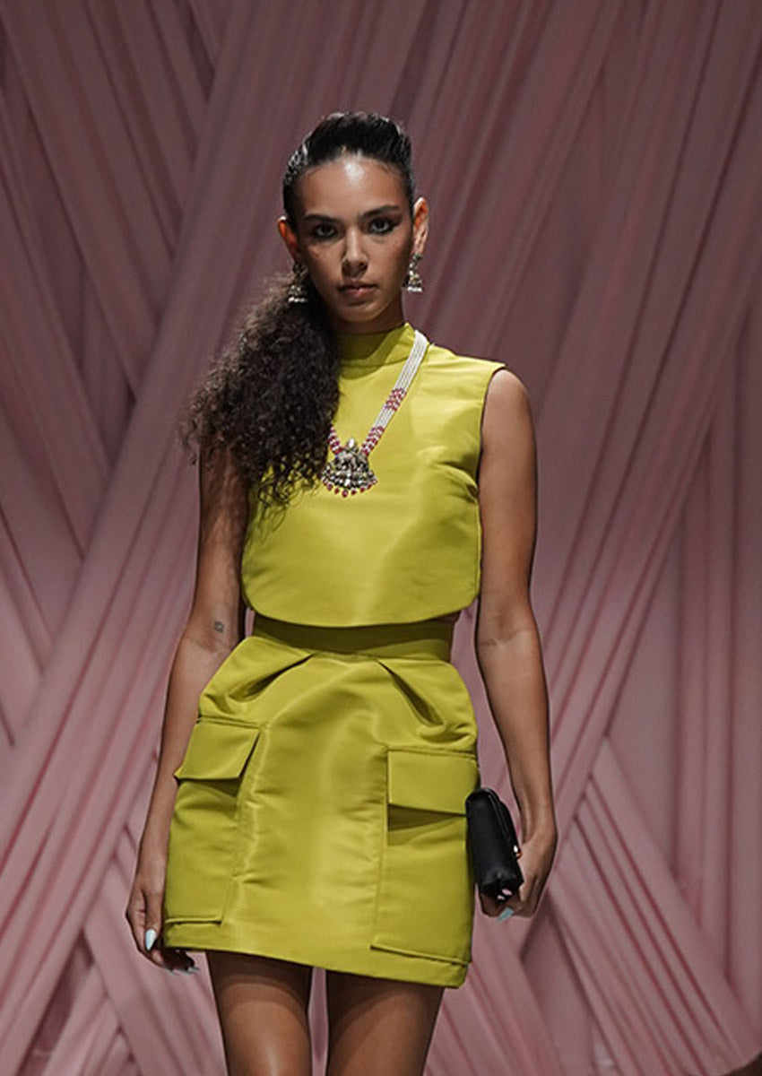 Woman in a bright green dress with a pink geometric background